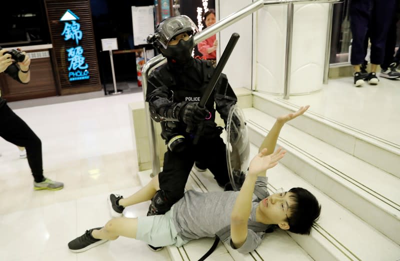 A protester is detained by riot police at a shopping mall in Tai Po in Hong Kong