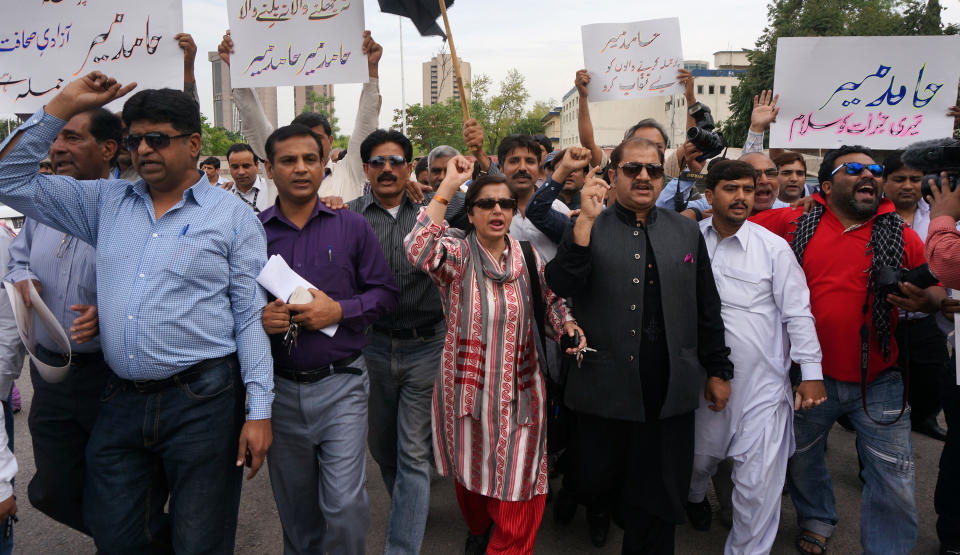 Pakistani journalists protest for their colleague Hamid Mir, who was shot and injured by gunmen in Karachi on Saturday, Monday, April 21, 2014 in Islamabad, Pakistan. Police in Pakistan said gunmen shot a famous television talk show host amid a wave of attacks on journalists in the country. Police say Hamid Mir, a host on the private television broadcaster Geo, was wounded in the attack Saturday, April 19, 2014, near Karachi's airport. Placard on right reads "we salute Hamid Mir for his courage." (AP Photo/B.K. Bangash)