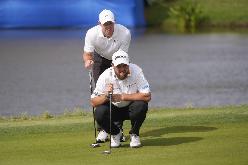 Rory McIlroy, of Northern Ireland, standing, and his teammate Shane Lowry, of Ireland, line up a shot on the 17th green during the final round of the PGA Zurich Classic golf tournament at TPC Louisiana in Avondale, La., Sunday, April 28, 2024. (AP Photo/Gerald Herbert)