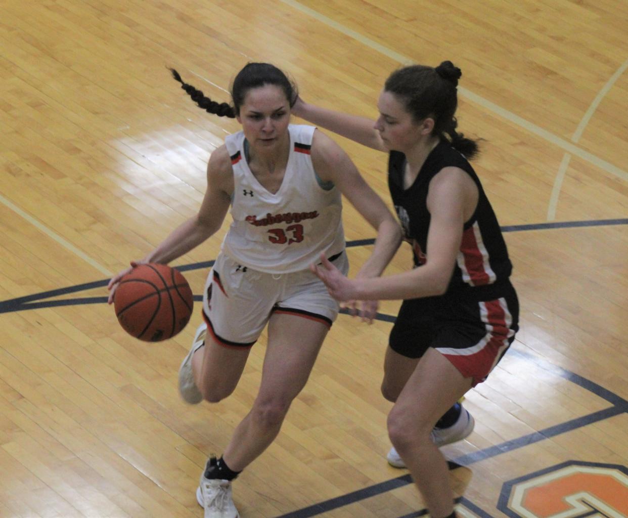 Cheboygan senior guard Kenzie Burt (left) looks to drive past an East Jordan player during the first half of a varsity girls basketball contest in Cheboygan on Monday.