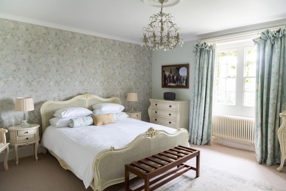 a blue and white bedroom with a bed and a chandelier