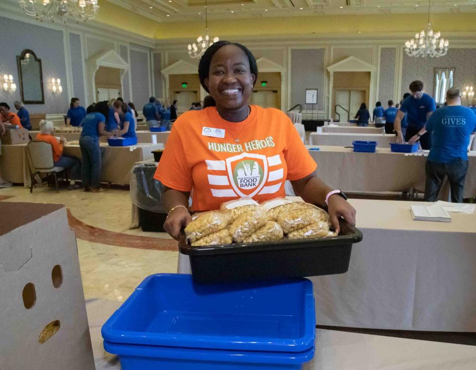 Rose Norzea carries a container full of pasta meals.