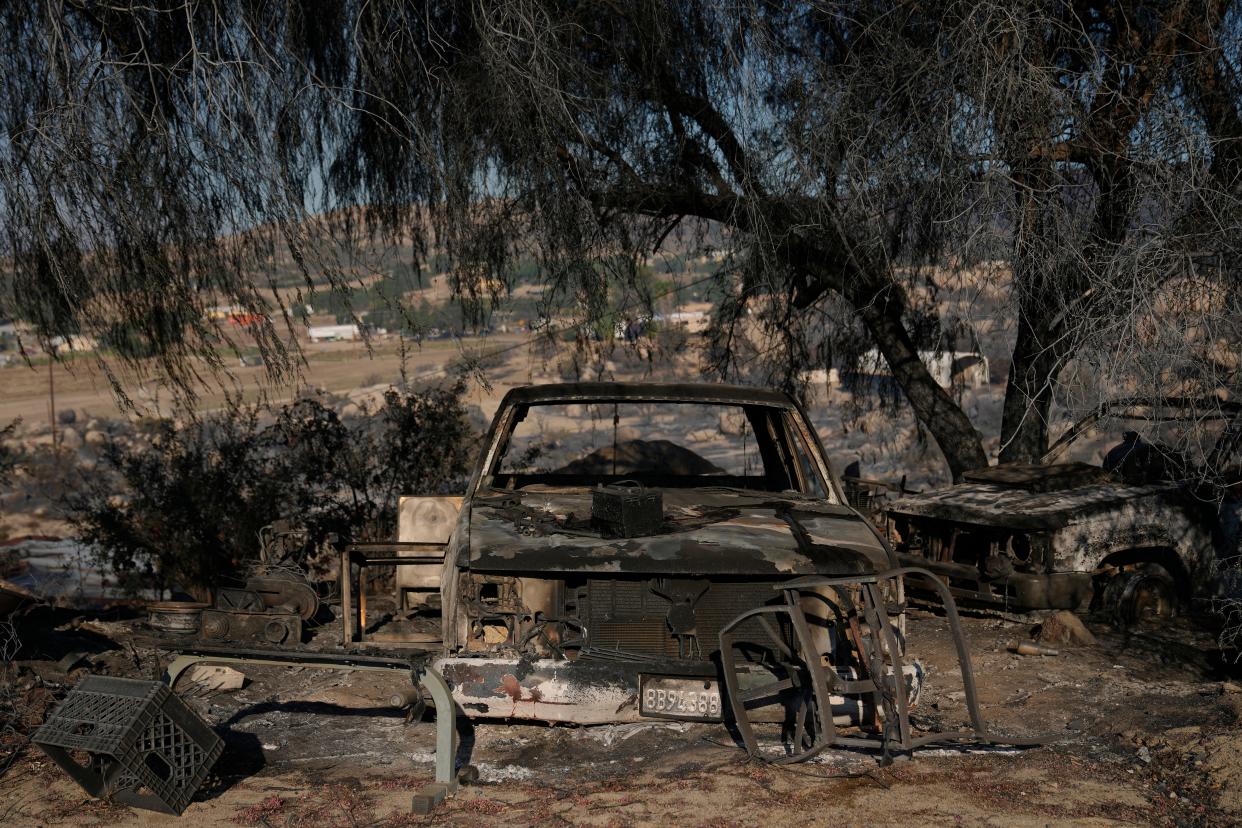 A burned vehicle is seen Tuesday on Luis Quinonez's property in Aguanga after the Highland Fire passed through.