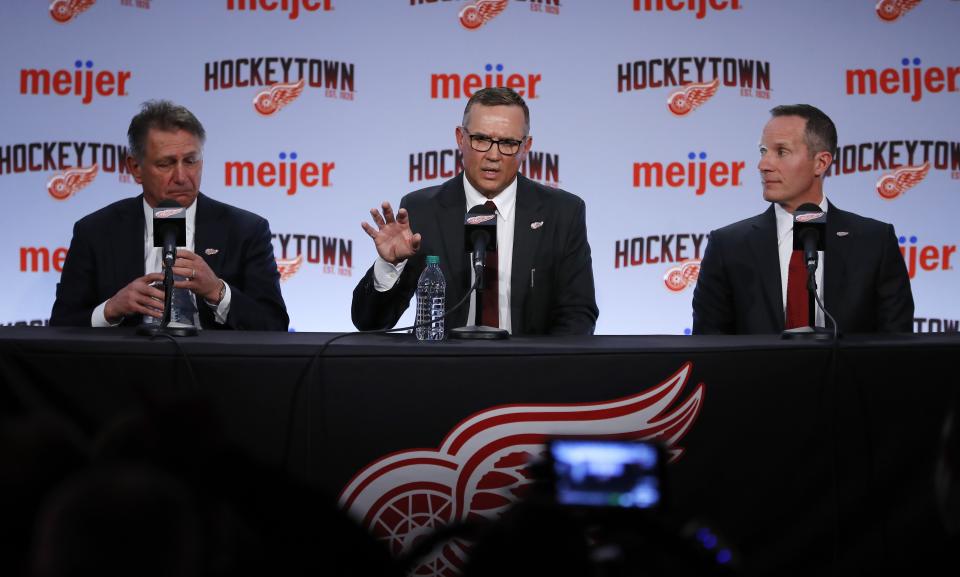 Steve Yzerman, center, addresses the media during an NHL hockey news conference where he was introduced as the new executive vice president and general manager of the Detroit Red Wings, Friday, April 19, 2019, in Detroit.. At left is senior vice president Ken Holland, and at right is Christopher Ilitch, president and CEO of Ilitch Holdings, Inc. (AP Photo/Carlos Osorio)