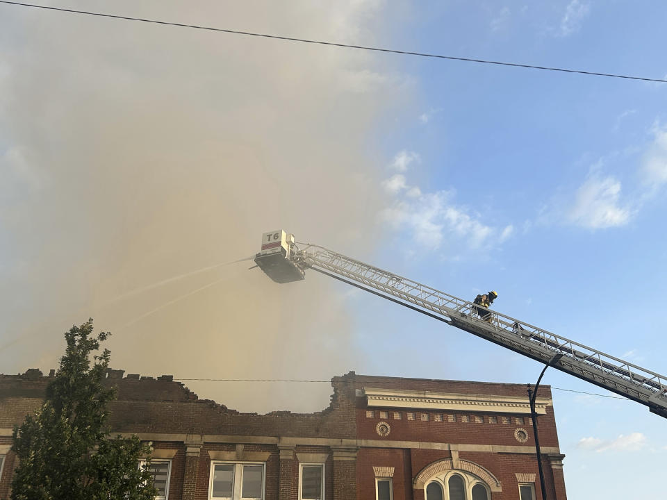 Members of the Bowling Green Fire Department work to extinguish an early morning structure fire on State Street Friday, July 21, 2023 in Bowling Green, Ky. The building, home to Senator Rand Paul's Bowling Green local office, sustained heavy damage, including a roof collapse. (Jake Moore/Daily News via AP)