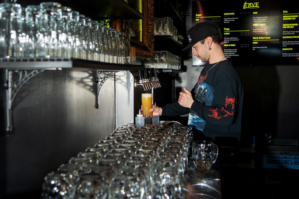 Logan Olds, a bartender at Trve Brewing, pours a glass of Chapel of Ghouls, a hazy IPA, March 19, 2024.
