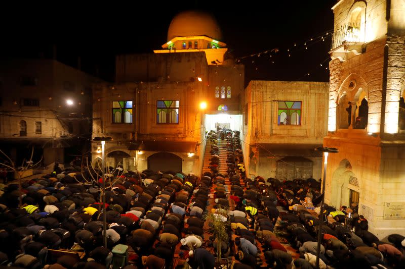 Palestinians perform the Fajr (Dawn) prayers outside Al-Nasir mosque in Nablus, in the Israeli-occupied West Bank