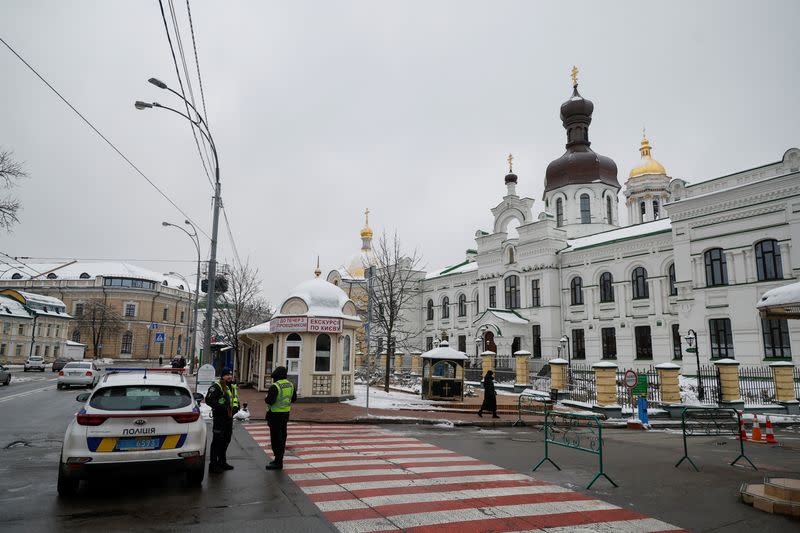 Ukrainian law enforcement officers stand next to an entrance to the Kyiv Pechersk Lavra monastery compound in Kyiv