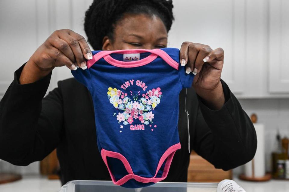 LaChunda Hunter holds a onesie that had been given to her baby girl, Legacy, who was born prematurely at Novant’s main hospital in Charlotte in February 2022.