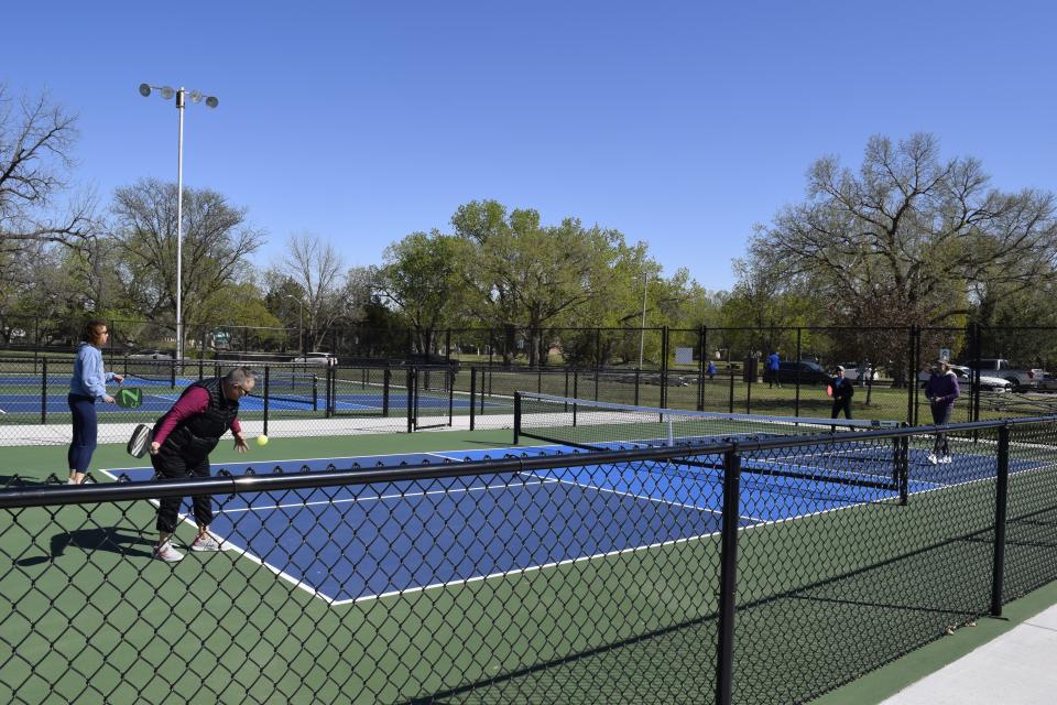 Stephanie Weckel, who is playing with Gail Boyer, serves the ball to Rachel Krier and Lisa Short on one of the new pickleball courts at Oakdale Park. The courts, which were privately funded by a group of enthusiasts, hosted an official ribbon cutting on Thursday.