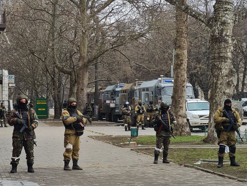 Des soldats russes face à des manifestants ukrainiens à Kherson.