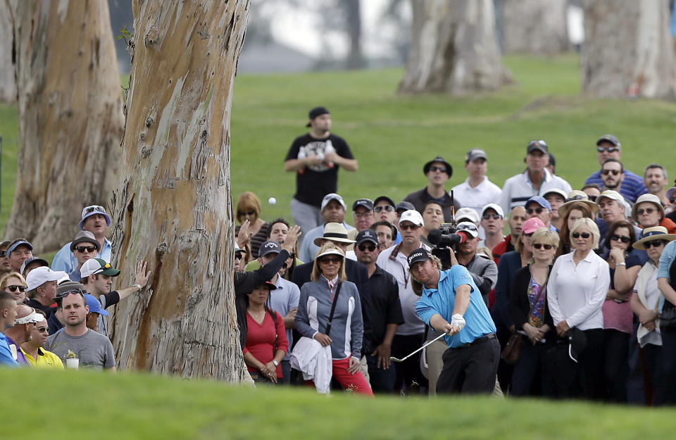 William McGirt hits from the trees on the 18th fairway in the third round of the Northern Trust Open golf tournament at Riviera Country Club in the Pacific Palisades area of Los Angeles, Saturday, Feb. 15, 2014. (AP Photo/Reed Saxon)