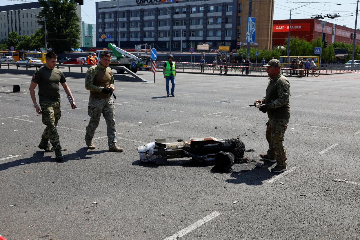 Police officers walk next to a part of a missile which landed on a street during a Russian strike on Kyiv on May 29 (REUTERS)