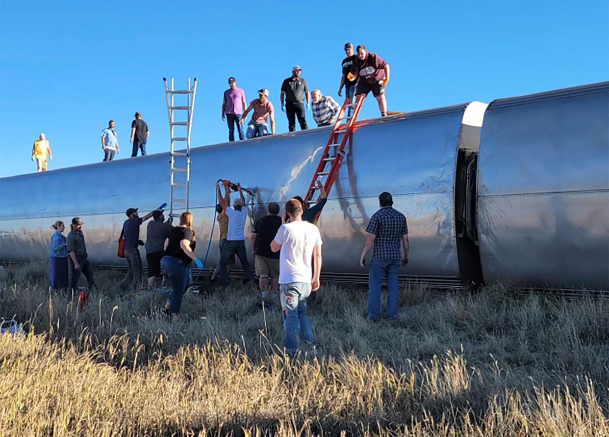 People at the scene help to evacuate passengers from the Amtrak train, which derailed at 4pm on Saturday  (Kimberly Fossen)