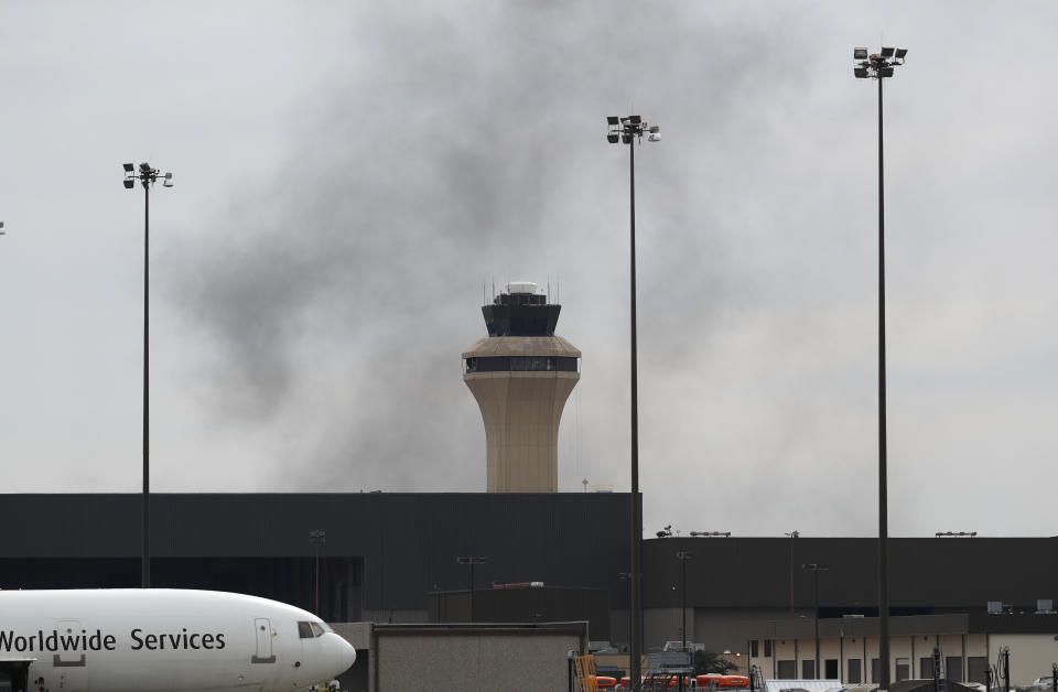 Smoke drifts near an air traffic control tower on west side of Dallas/Fort Worth International Airport in Grapevine, Dallas, Wednesday, Feb. 13, 2019. Flights at Dallas' two major airports were temporarily halted after air traffic controllers were forced to evacuate a building because of smoke, and the resulting flight delays are expected to continue for hours. (AP Photo/LM Otero)