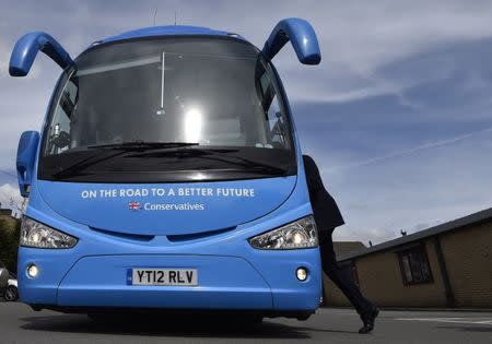 FILE PHOTO: Britain's Prime Minister David Cameron walks back onto his Conservative Party campaign bus after a factory visit whilst campaigning in Pendle in northern England, Britain, May 1, 2015. REUTERS/Toby Melville