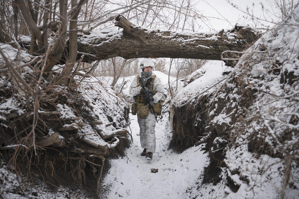 Ukrainian serviceman Ivan Skuratovskyi walks in a trench at a frontline position outside Avdiivka, Donetsk region, eastern Ukraine, Friday, Feb. 4, 2022. Even as the rhetoric out of Washington ramps up, a sense of calm prevails in the Eastern European nation among soldiers and citizens alike, from relatives of those in the trenches on up to President Volodymyr Zelenskyy, who campaigned on a promise of ending the drawn-out conflict and has repeatedly called for diplomacy to carry the day. (AP Photo/Vadim Ghirda)