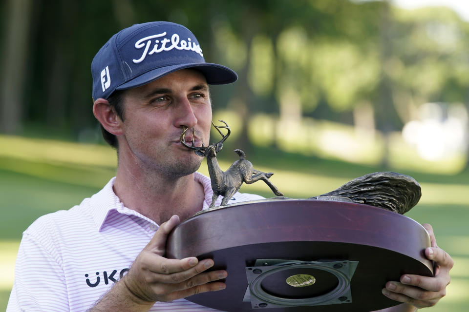 J.T. Poston kisses the trophy after winning the John Deere Classic golf tournament, Sunday, July 3, 2022, at TPC Deere Run in Silvis, Ill. (AP Photo/Charlie Neibergall)