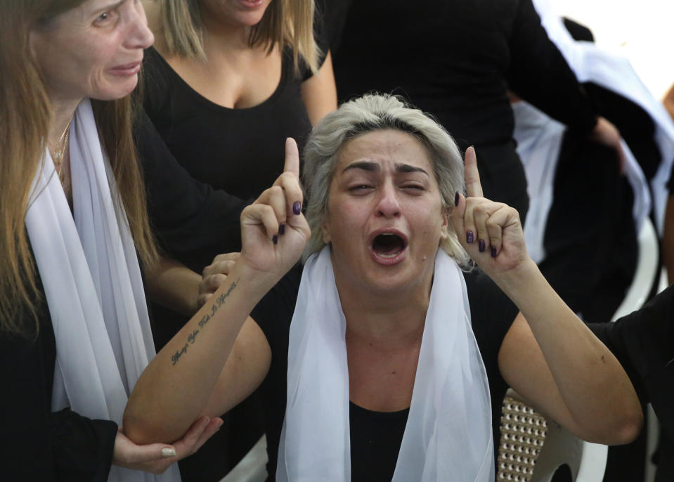 Lara, the wife of Alaa Abu Fakher, a local official with the Progressive Socialist Party who killed by a Lebanese soldier during Tuesday night protests south of Beirut, mourns her husband with other relatives, in Choueifat neighborhood, Lebanon, Wednesday, Nov. 13, 2019. Lebanese protesters are blocking major highways with burning tires and roadblocks, saying they will remain in the streets following a televised interview in which the president urged them to go home. (AP Photo/Hussein Malla)