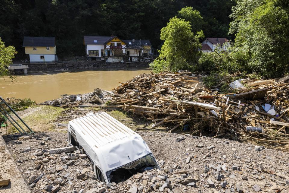 A van buried in debris and gravel on the banks of the river Ahr in Ahrbruck, Germany, Susnday July 18, 2021. Heavy rains caused mudslides and flooding in the western part of Germany. Multiple have died and are missing as severe flooding in Germany and Belgium turned streams and streets into raging, debris-filled torrents that swept away cars and toppled houses. (Philipp von Ditfurth/dpa via AP)