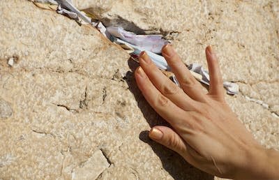 A woman slides a written prayer into a crack in the Western Wall beside the Temple Mount in Jerusalem. <a href="https://www.gettyimages.com/detail/photo/prayers-at-the-western-wall-in-jerusalem-royalty-free-image/183511454?phrase=%22western%20wall%22&adppopup=true" rel="nofollow noopener" target="_blank" data-ylk="slk:Joel Carillet/iStock via Getty Images Plus;elm:context_link;itc:0;sec:content-canvas" class="link ">Joel Carillet/iStock via Getty Images Plus</a>