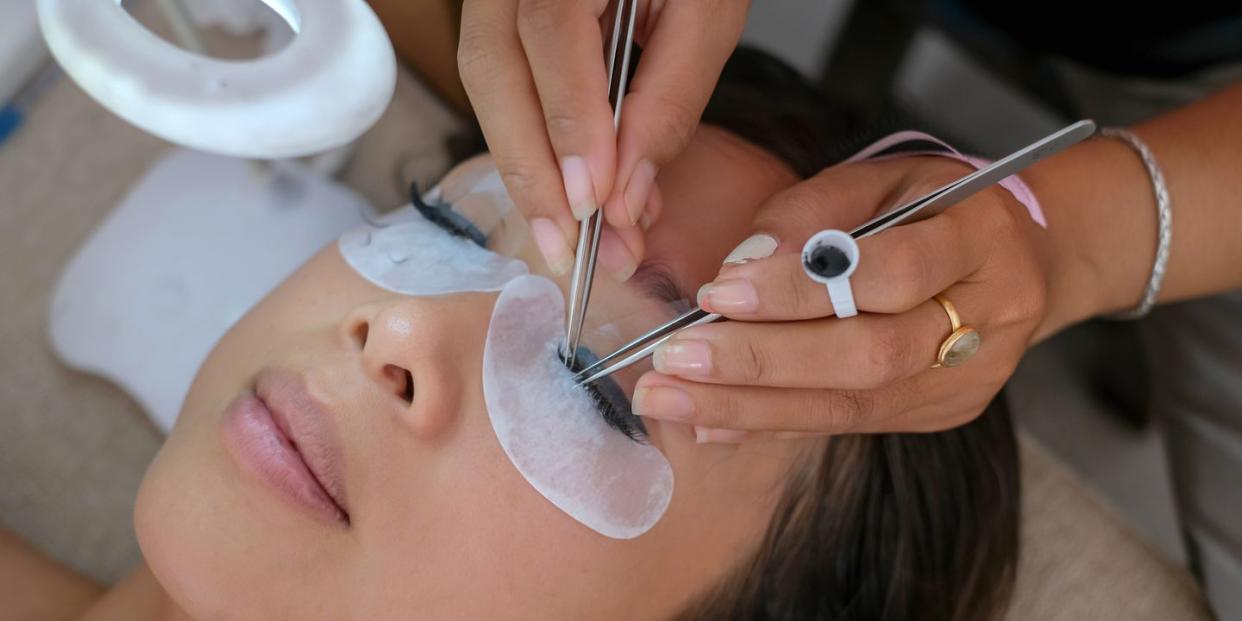 beautiful woman getting home service eyelash extension