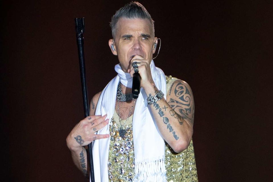 <p>Joe Giddens/PA Images via Getty</p> Robbie Williams performs in August 2023