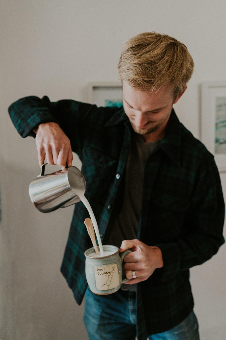 Cole VanderLeest pours hot milk over a hot chocolate spoon, a coated wooden spoon that makes hot chocolate when the milk is added.