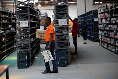 A man walks past shelves with branded packets at a warehouse for an online store, Jumia in Ikeja district, in Nigeria's commercial capital Lagos June 10, 2016. REUTERS/Akintunde Akinleye