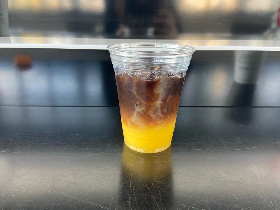 The coffee and orange juice separated into two distinct layers in the cup