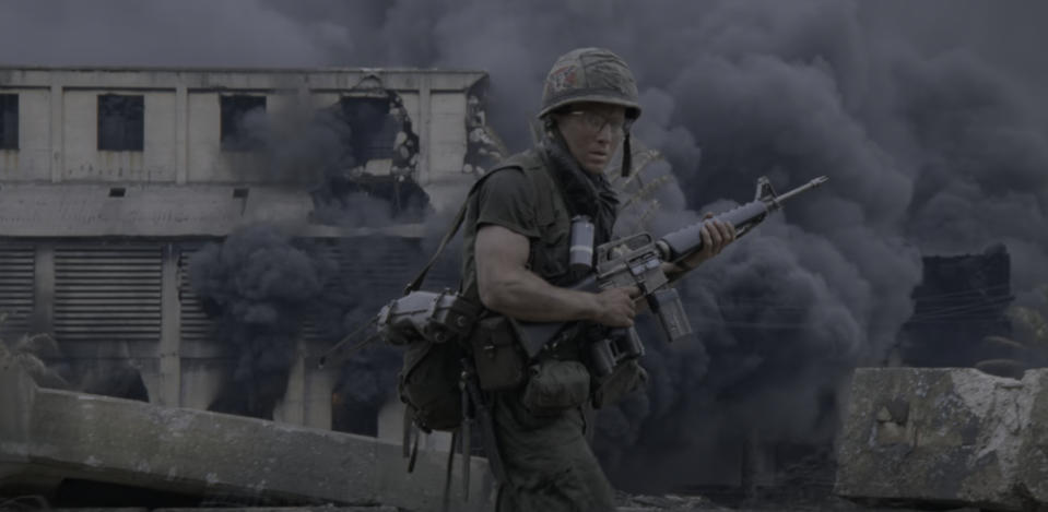 a soldier walks through ruins