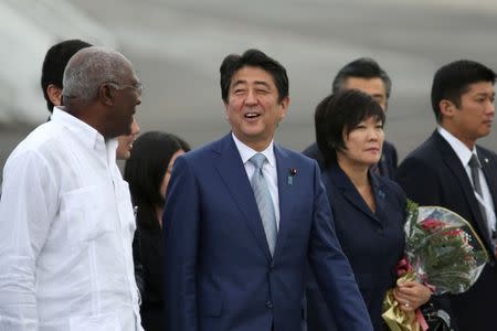 Japan's Prime Minister Shinzo Abe (C), talks to Salvador Antonio Valdes Mesa, member of the Political Bureau of the Central Committee of the Communist Party of Cuba (CPC) and vice-president of the Council of State of Cuba (L) upon his arrival at the Jose Marti International Airport in Havana, Cuba, September 22, 2016. REUTERS/Alexandre Meneghini