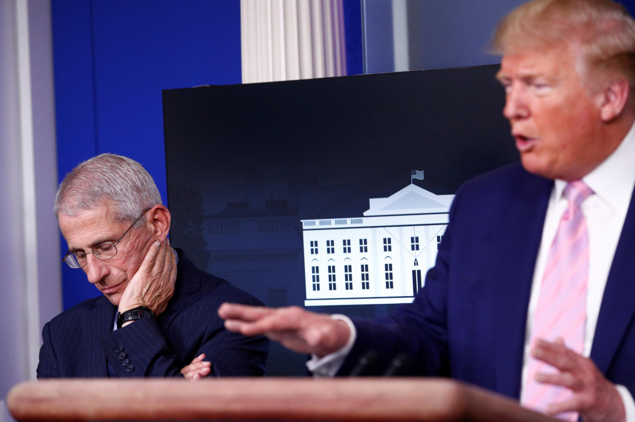 Dr. Anthony Fauci, director of the National Institute of Allergy and Infectious Diseases, listens as U.S. President Donald Trump addresses the daily coronavirus response briefing at the White House in Washington, U.S., April 1, 2020. REUTERS/Tom Brenner