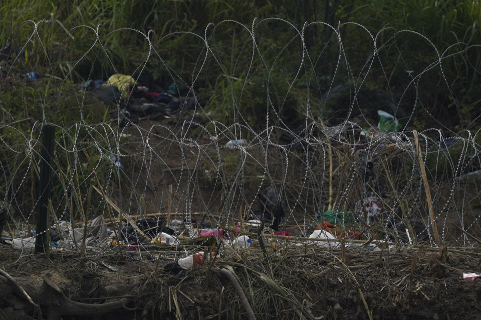 Razor wire and trash cover the U.S. side of the Rio Grande river, empty the morning after U.S. pandemic-related asylum restrictions called Title 42 were lifted, seen from Matamoros, Mexico, early Friday, May 12, 2023. (AP Photo/Fernando Llano)