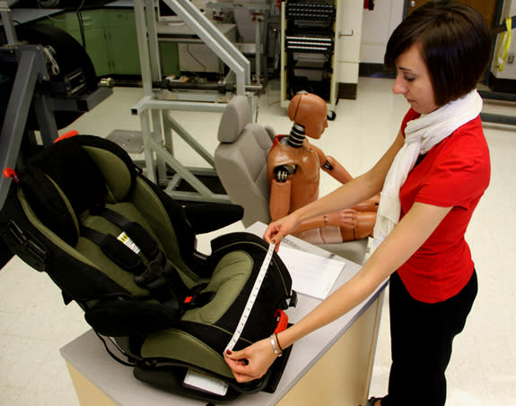 Julie Bing, a researcher with the Ohio State University College of Medicine, measures the dimensions of a child's car seat. She and her colleagues measured and analyzed nearly 3,200 car and car-seat combinations. They found that not all car sea