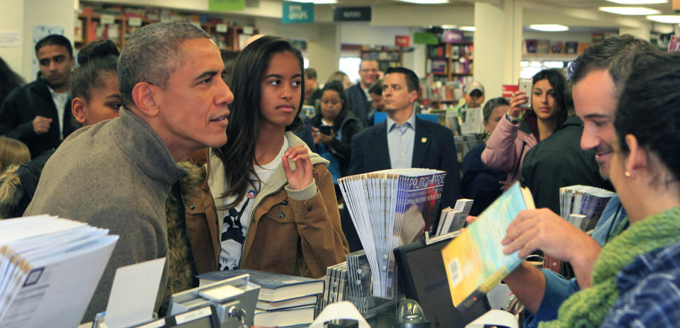 President Barack Obama and daughters Sasha and Malia purchase books at Politics and Prose bookstore for 'Small Business Saturday' on November 29, 2014 in Washington, DC.