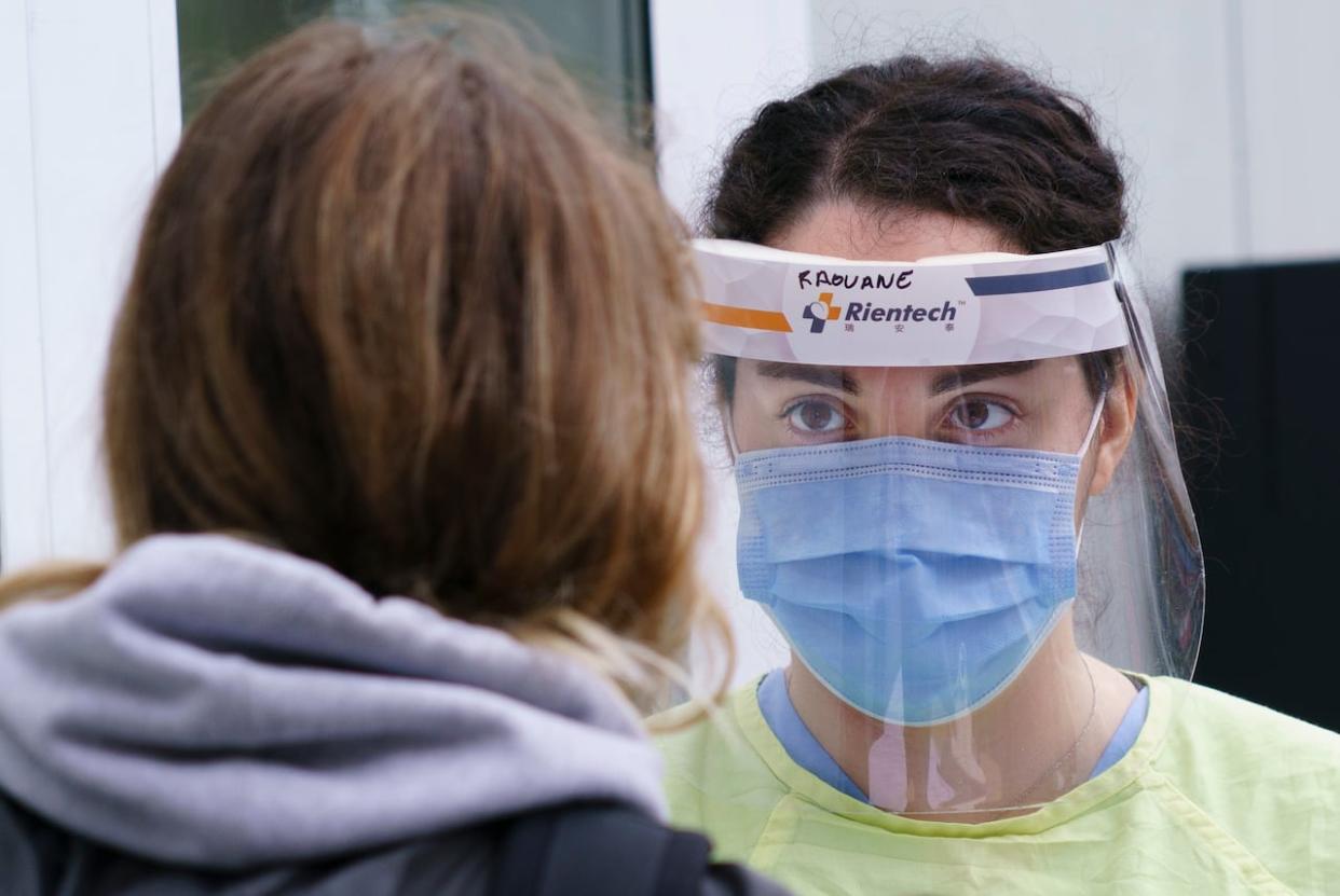 A nurse greets a woman at a walk-in clinic in Montreal. In a bid to increase the number of doctors and nurses practising in rural and remote areas, the federal government announced Tuesday it would increase forgivable loans for some students.  (Paul Chiasson/Canadian Press - image credit)