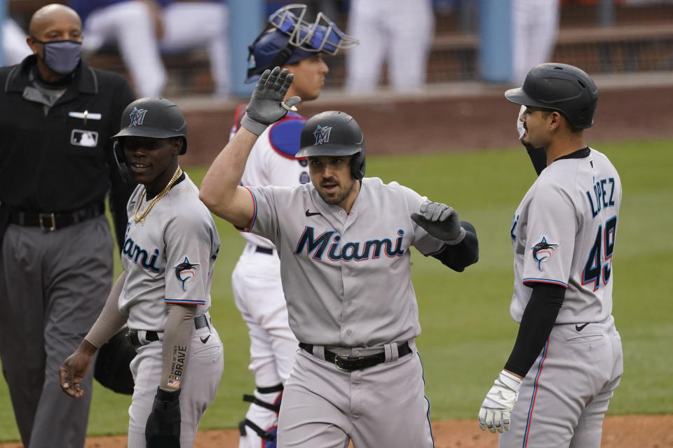 Miami Marlins' Adam Duvall (14) celebrates after hitting a home run during the fifth inning of a baseball game against the Los Angeles Dodgers Sunday, May 16, 2021, in Los Angeles. Pablo Lopez, right, and and Jazz Chisholm Jr., left, scored. (AP Photo/Ashley Landis)