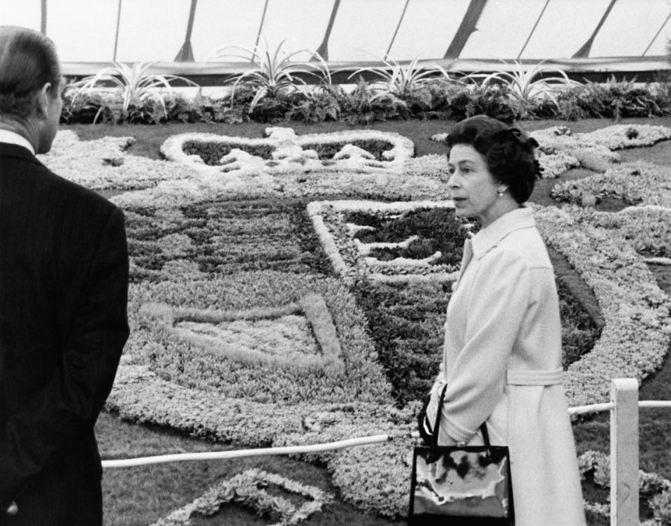 <p>Queen Elizabeth II and Prince Philip viewing the carpet bedding of the Royal Coat of Arms during a tour of RHS Chelsea in May 1975.</p>