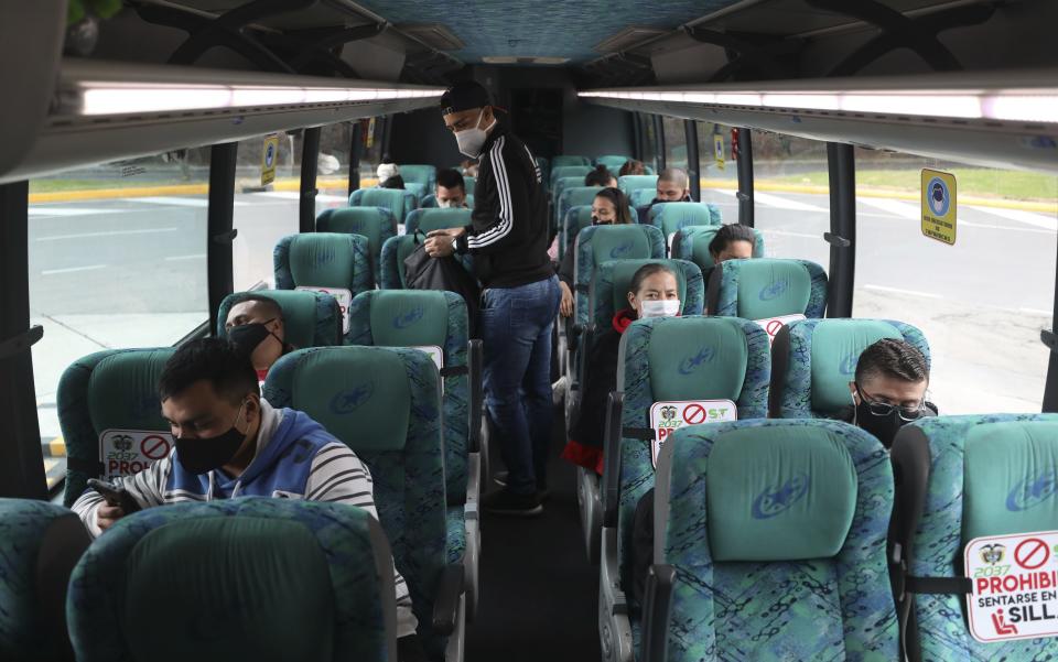 Passengers sit on a bus at the terminal for long-distance travel in Bogota, Colombia, Tuesday, Sept. 1, 2020. Airports, land transport, restaurants, and gyms are reopening in most of Colombia this week, as the South American nation attempts to reignite its economy following months of restrictions related to the coronavirus pandemic. (AP Photo/Fernando Vergara)