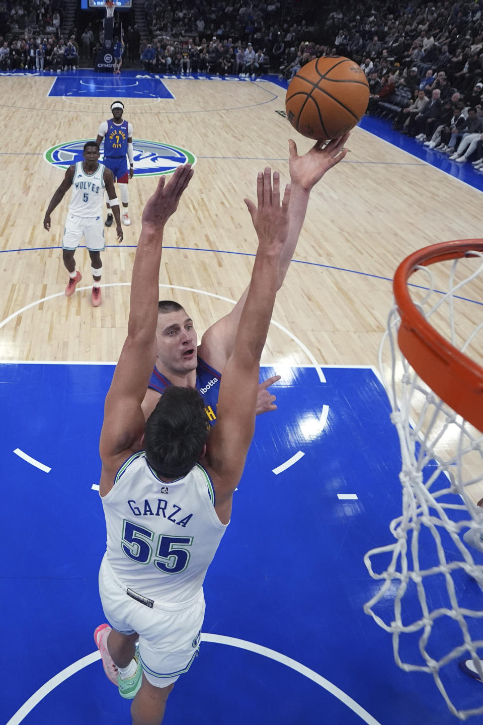 Denver Nuggets center Nikola Jokic shoots over Minnesota Timberwolves center Luka Garza (55) during the first half of an NBA basketball game Tuesday, March 19, 2024, in Minneapolis. (AP Photo/Abbie Parr)