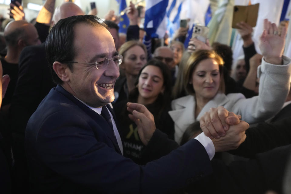 Cypriot Presidential candidate Nicos Christodoulides, with his wife Philippa, center rear, greets his supporters during a campaign rally in Nicosia, Cyprus, Sunday, Jan. 29, 2023. A youthful former foreign minister who campaigned as a unifier unconstrained by antiquated ideological and party lines will take on a veteran diplomat with broad voter appeal in a Feb. 12 runoff for the presidency of ethnically divided Cyprus. Cyprus' former top diplomat Nikos Christodoulides, 49, came out on top with 32% of the vote in the Feb. 5 first round. Andreas Mavroyiannis, 66, clinched second place with a surprisingly strong showing of 29.6% of votes. (AP Photo/Petros Karadjias)