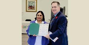 Owner Lakshmi Bhamidipati (left) is presented with a Certificate of Appreciation by Chief Guest Brian Masse, Member of Parliament (right) at the Grand Opening for Minuteman Press, Windsor, Ontario, November 9th, 2022.