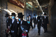 A group of ultra-Orthodox Jewish youth wear protective face masks following government measures to help stop the spread of the coronavirus, as they walk in Jerusalem's Old City, Thursday, July 16, 2020. (AP Photo/Oded Balilty)