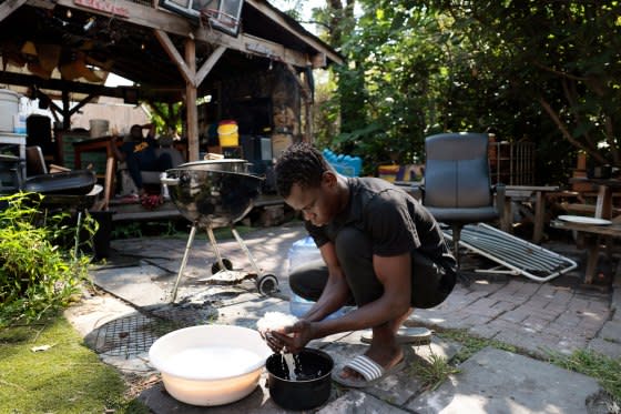 A migrant from Mauritania washes rice at Bushwick City Farm, which had provided migrants who were staying in a shelter across the street with fresh produce and invited them to use their space for cooking, on Aug. 16, 2023.<span class="copyright">Jessica Rinaldi—The Boston Globe/Getty Images</span>