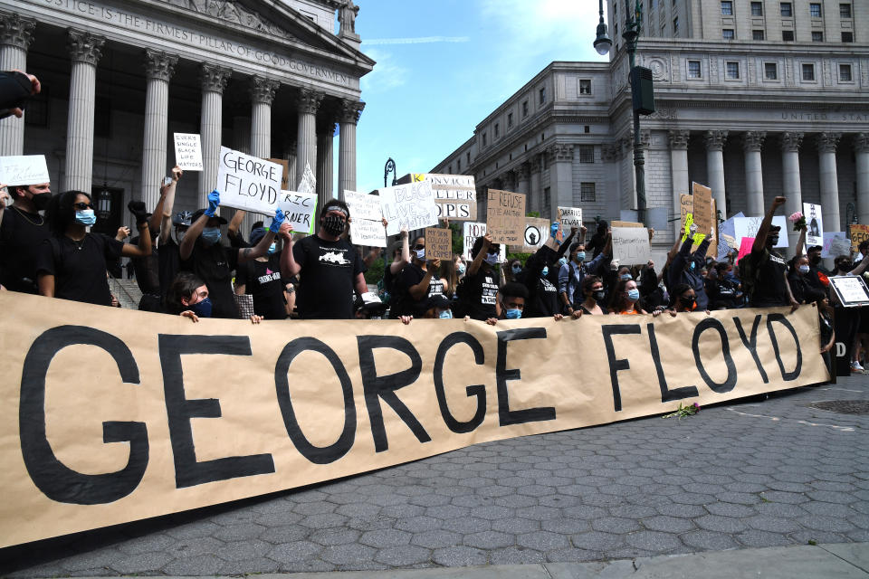 NEW YORK, NEW YORK - MAY 29:  Protestors gather behind a banner spelling the name of George Floyd, a black man who died after a white policeman kneeled on his neck during a "Black Lives Matter" protest on May 29, 2020 at Foley Square in New York City.  Demonstrations are being held across the US after George Floyd died in police custody on May 25. (Photo by Kevin Mazur/Getty Images)