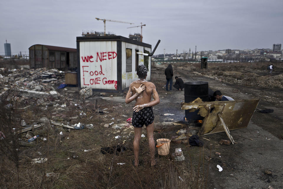 <p>Unaccompanied minor, a migrant from Afghanistan, showers on a cold day near an old train carriage where he and other migrants took refuge in Belgrade, Serbia on Feb 11, 2017. (Photo: Muhammed Muheisen/AP) </p>