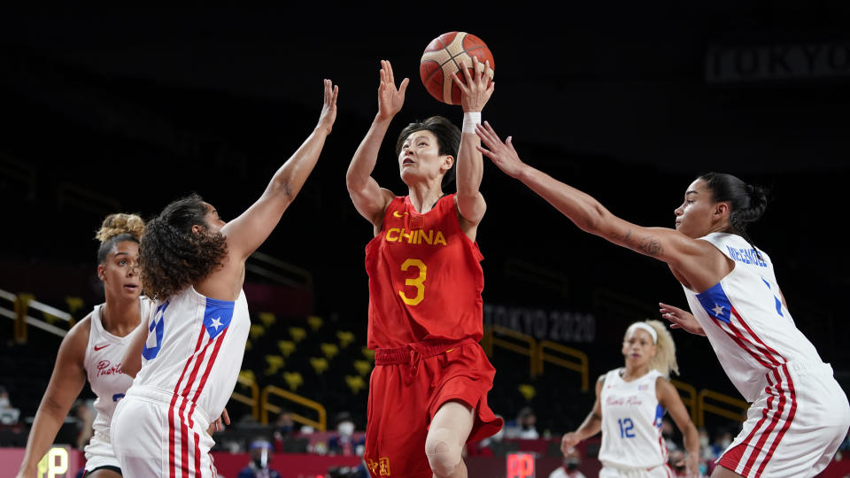 China's Liwei Yang (3) drives between Puerto Rico's Jennifer O'Neill, left, and Tayra Melendez, right, during a women's basketball preliminary round game at the 2020 Summer Olympics in Saitama, Japan, Tuesday, July 27, 2021. (AP Photo/Charlie Neibergall)