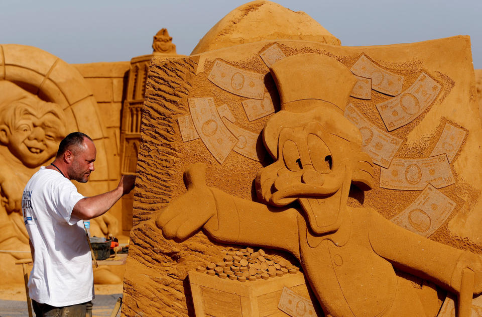 <p>Sand carver Teimur Ilya Shanin from Russia works on a sculpture during the Sand Sculpture Festival “Disney Sand Magic” in Ostend, Belgium June 22, 2017. (Yves Herman/Reuters) </p>
