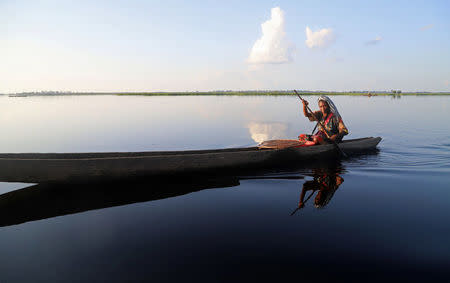 A Congolese woman rows her boat along the Congo River during the vaccination campaign aimed at beating an outbreak of Ebola in the port city of Mbandaka, Democratic Republic of Congo May 22, 2018. REUTERS/Kenny Katombe